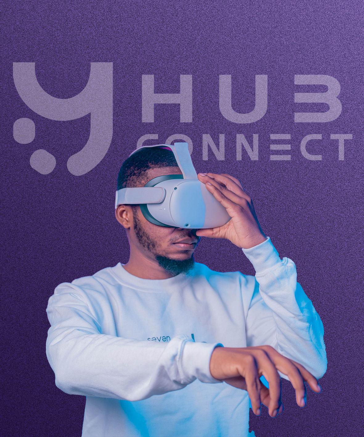 Yon jèn gason ak yon kas reyalite vityèl devan logo Hubconnect la